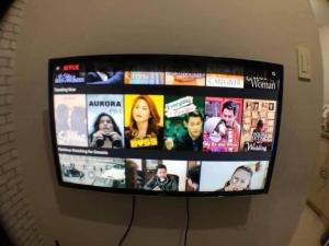 a television screen with pictures of people on it at The Grass Residences in Manila +3 photos