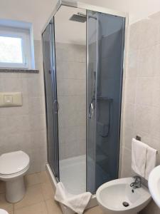 a bathroom with a shower and a toilet and a sink at Garden Hotel Alghero in Fertilia