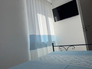 a bedroom with a bed and a window with a curtain at Garden Hotel Alghero in Fertilia
