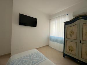 a bedroom with a bed and a tv on a wall at Garden Hotel Alghero in Fertilia