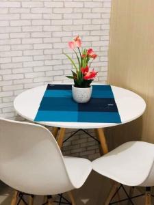 a table with a potted plant on it with two chairs at The Grass Residences in Manila