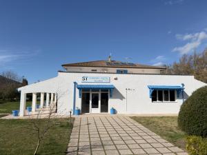 a white building with a blue roof at Garden Hotel Alghero in Fertilia