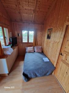 1 dormitorio con 1 cama en una habitación de madera en Casa de madera en urbanización con gran piscina entre pinos, en Liria