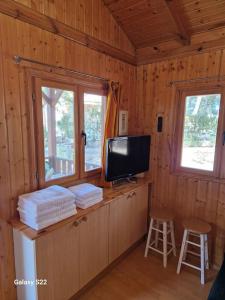cabina con TV y barra con taburetes en Casa de madera en urbanización con gran piscina entre pinos, en Liria