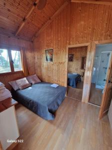 1 dormitorio con 1 cama en una habitación de madera en Casa de madera en urbanización con gran piscina entre pinos, en Liria