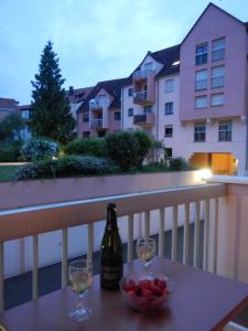 a table with a bottle of wine and a bowl of fruit at Klipfel Little Venice in Colmar