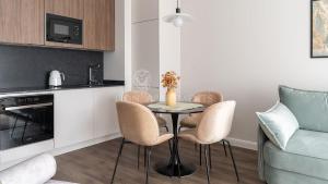 a small kitchen with a table and chairs in a room at Lion Apartments - SCALA City Center Apartments&Parking IA in Gdańsk