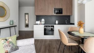 a living room with a kitchen and a dining room at Lion Apartments - SCALA City Center Apartments&Parking IA in Gdańsk