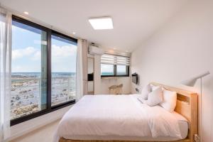 1 dormitorio con 1 cama grande y ventanas grandes en On The Sea Pension en Jeju