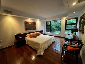 a bedroom with a large bed and a large window at La Kaz' Bougainvilliers in Bel Ombre