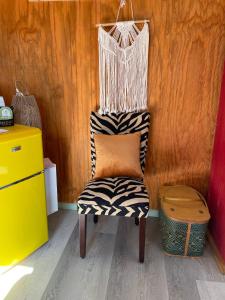 a black and white chair with an orange pillow on it at En Suite Flora in Dripping Springs