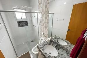 a bathroom with a sink and a shower and a toilet at 104 - Apartamento Completo para até 7 Hóspedes in Patos de Minas