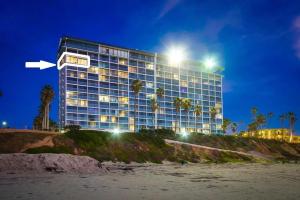 a tall building with lights on top of a beach at Capri by the Sea in San Diego