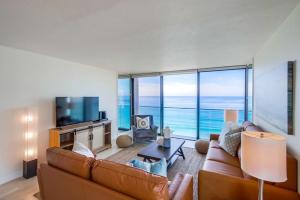 a living room with a couch and a television at Capri by the Sea in San Diego