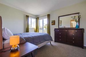 1 dormitorio con cama, tocador y espejo en Endless Summer 2, en San Diego