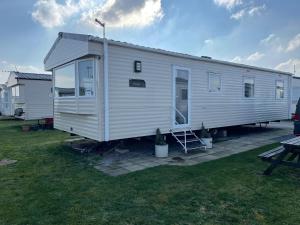 a large white modular home on a lawn at Brambles 66 -Static Holiday Caravan, Porthcawl in Newton