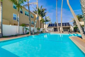 una piscina frente a un edificio con palmeras en Capri by the Sea en San Diego