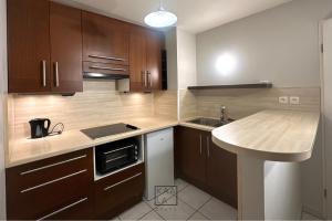 a kitchen with wooden cabinets and a sink at KAALA STAYS - APT spacieux Paris-Disneyland in Noisy-le-Grand