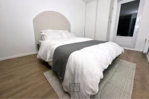a bedroom with a bed with white sheets and a window at KAALA STAYS - APT spacieux Paris-Disneyland in Noisy-le-Grand