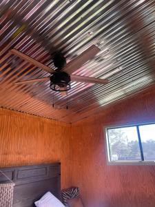 a ceiling fan in a room with a window at En Suite Flora in Dripping Springs