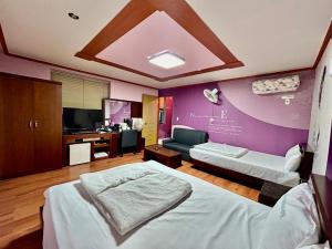 a hotel room with two beds and a tv at Evergreen motel in Geoje