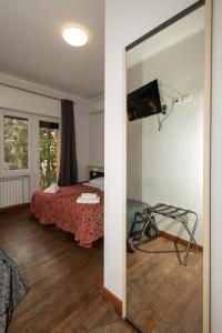 Habitación con cama, espejo y TV. en Villa Gioia, en Milán