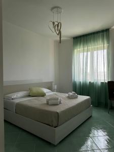 - une chambre avec un grand lit et une fenêtre dans l'établissement Ohana Affittacamere, à San Nicola Arcella