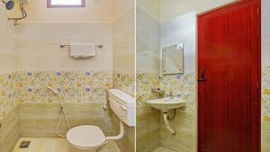 a bathroom with a toilet and a sink and a red door at SAI BALAVANY RESIDENCY Pondicherry in Puducherry