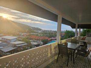 einen Balkon mit einem Tisch und Stühlen sowie Aussicht in der Unterkunft Castle Villa Phuket in Kamala Beach