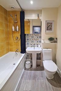 a bathroom with a toilet and a tub and a sink at Central London 1 bedroom flat in Kensington in London