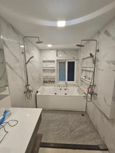 ein weißes Badezimmer mit einer Badewanne und einem Waschbecken in der Unterkunft Castle Villa Phuket in Kamala Beach