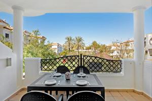een patio met een tafel en stoelen op een balkon bij Apartamento Coto 109 in Chiclana de la Frontera