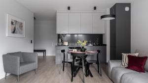 uma sala de estar com uma mesa e uma cozinha em Lion Apartments - SCALA City Center Apartments&Parking IIB em Gdansk