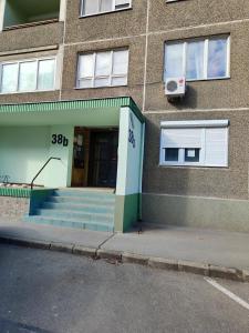 ein Gebäude mit einer Tür und einer Treppe davor in der Unterkunft Hegin Exclusiv Home in Budapest