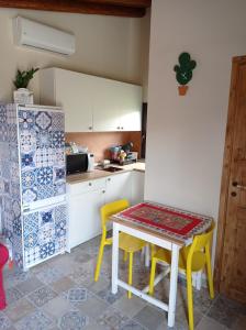 uma cozinha com uma mesa e duas cadeiras amarelas em Ai tre desideri la casita em Aci Castello
