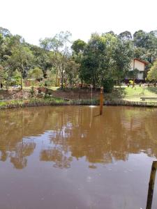 une grande étendue d'eau dans un parc dans l'établissement CHALÉS LUAR DO PICO, à Santo Antônio do Pinhal