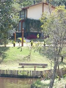 un banc de parc assis devant une maison dans l'établissement CHALÉS LUAR DO PICO, à Santo Antônio do Pinhal