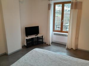 a living room with a television and a window at La Caravelle 3 in Thiers
