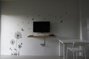 a living room with a tv on a wall with butterflies at Better Weather Homestay in Pak Chong