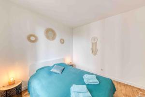 讓蒂伊的住宿－Appartement cosy au calme, proche de Paris et du RER B，一间卧室配有蓝色的床和毛巾