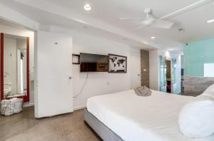 a white bedroom with a large bed and a flat screen tv at Kettner Row 1 in San Diego