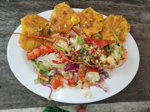 un plato de comida con ensalada y patatas fritas en Mares gunayarIslas en Nusatupo