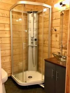La salle de bains est pourvue d'une douche avec une porte en verre. dans l'établissement Beautiful and spacious lakeside cottages, à Imatra