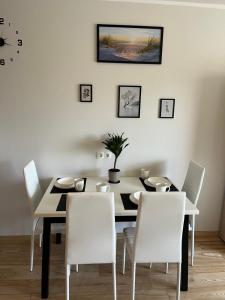 comedor con mesa y sillas blancas en Baltic Apartament en Liepāja