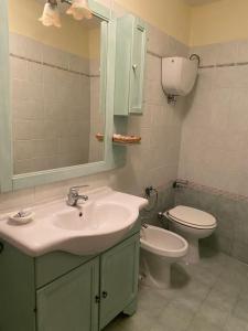 uma casa de banho com um lavatório, um WC e um espelho. em Appartamento San Sisto n 8 em Spello