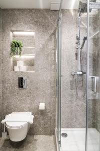 a bathroom with a shower and a toilet and a sink at London Luxury Apartments in High Wycombe in Buckinghamshire