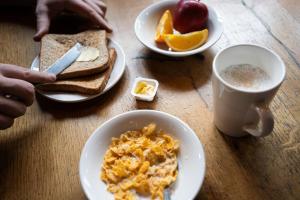 einen Tisch mit Frühstücksteller und einer Tasse Kaffee in der Unterkunft St Christopher's Hammersmith in London