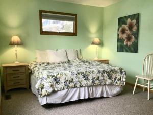 1 dormitorio con 1 cama, 2 mesas y 2 lámparas en Vacation Rental With Pool On Lbi, en Brant Beach