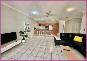 uma sala de estar com um sofá preto e uma cozinha em Riverside Boulevard 13-151 em Ross River