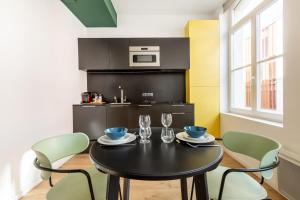 une salle à manger avec une table et des chaises noires dans l'établissement Le Chat Qui Dort - Vieux Lille II, à Lille